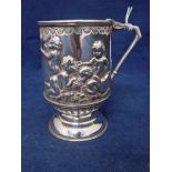 A late Victorian Silver Mug, straight sided circular form with domed foot, the body embossed with