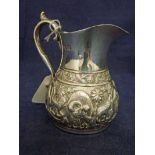 A late Victorian Silver Jug of typical form with cast S scroll handle, embossed with Indian