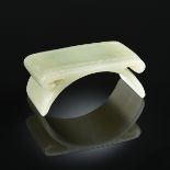 A CHINESE CARVED CELADON JADE BRUSH REST, 20TH CENTURY, of low arched table form with incised