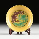 A CHINESE YELLOW GROUND PORCELAIN DRAGON DISH, the small dish with opposing aubergine and green