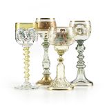 A GROUP OF FOUR BOHEMIAN AND GERMAN GILT AND ENAMEL DECORATED GLASS WINE STEMS, CIRCA 1880-1903,