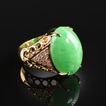 AN 18K YELLOW GOLD, JADE, AND DIAMOND LADY'S RING, the open work mounting centering a jade