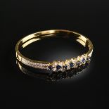 AN 18K YELLOW GOLD, SAPPHIRE, AND DIAMOND LADY'S HINGED BANGLE BRACELET, with seven square cut