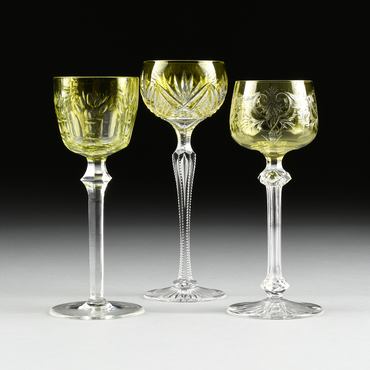 A GROUP OF THREE BOHEMIAN URANIUM CUT TO CLEAR WINE STEMS, CIRCA 1900-1930, comprising a wine