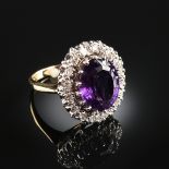 A 14K TWO TONE GOLD, DIAMOND, AND AMETHYST LADY'S RING, centering an oval amethyst.