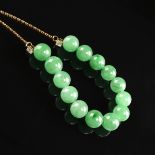 AN 18K YELLOW GOLD, JADE, AND DIAMOND LADY'S JADE NECKLACE, the gold chain suspending fourteen