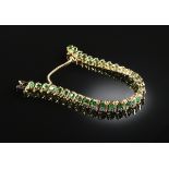 A 14K YELLOW GOLD AND EMERALD "S" LINK LADY'S TENNIS BRACELET, set with thirty-one round faceted