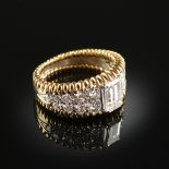 AN 18K TWO TONE GOLD AND EMERALD CUT DIAMOND LADY'S RING, centering one emerald cut diamond with