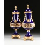 A PAIR OF SÃˆVRES STYLE NEOCLASSICAL GILT BRONZE MOUNTED COBALT BLUE PORCELAIN LIDDED URNS, BY