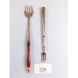 A white metal and agate handled miniature fork and another white metal fork