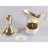 A silver cream jug Birmingham 1939 by S W Smith & Co 108g and a silver squat candlestick