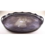 A large oval silver plated two handled tray with pierced shaped gallery standing on raised supports