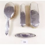 A silver four piece dressing table brush and mirror set
