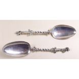 A pair of continental silver serving spoons, the stems cast figures holding bibles and crucifix,