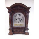 A oak cased architectural style chiming mantel clock with carved decoration