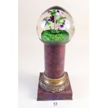 A Victorian flower form paperweight mounted on a red marble column 23cm tall