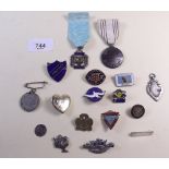 An interesting group of badges including Butlins, RSPCA etc and a silver medal