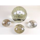 A Victorian large glass dump weight and three similar smaller paperweights