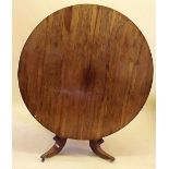 A Victorian rosewood tilt top circular dining table on square column and platform base with