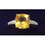 A 9 carat gold citrine ring on diamond set shoulders - size M