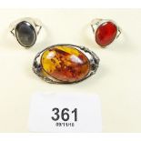 A silver and amber brooch and two silver stone set rings