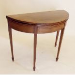 An early 19th century mahogany demi-lune fold top card table on tapered legs and with satinwood