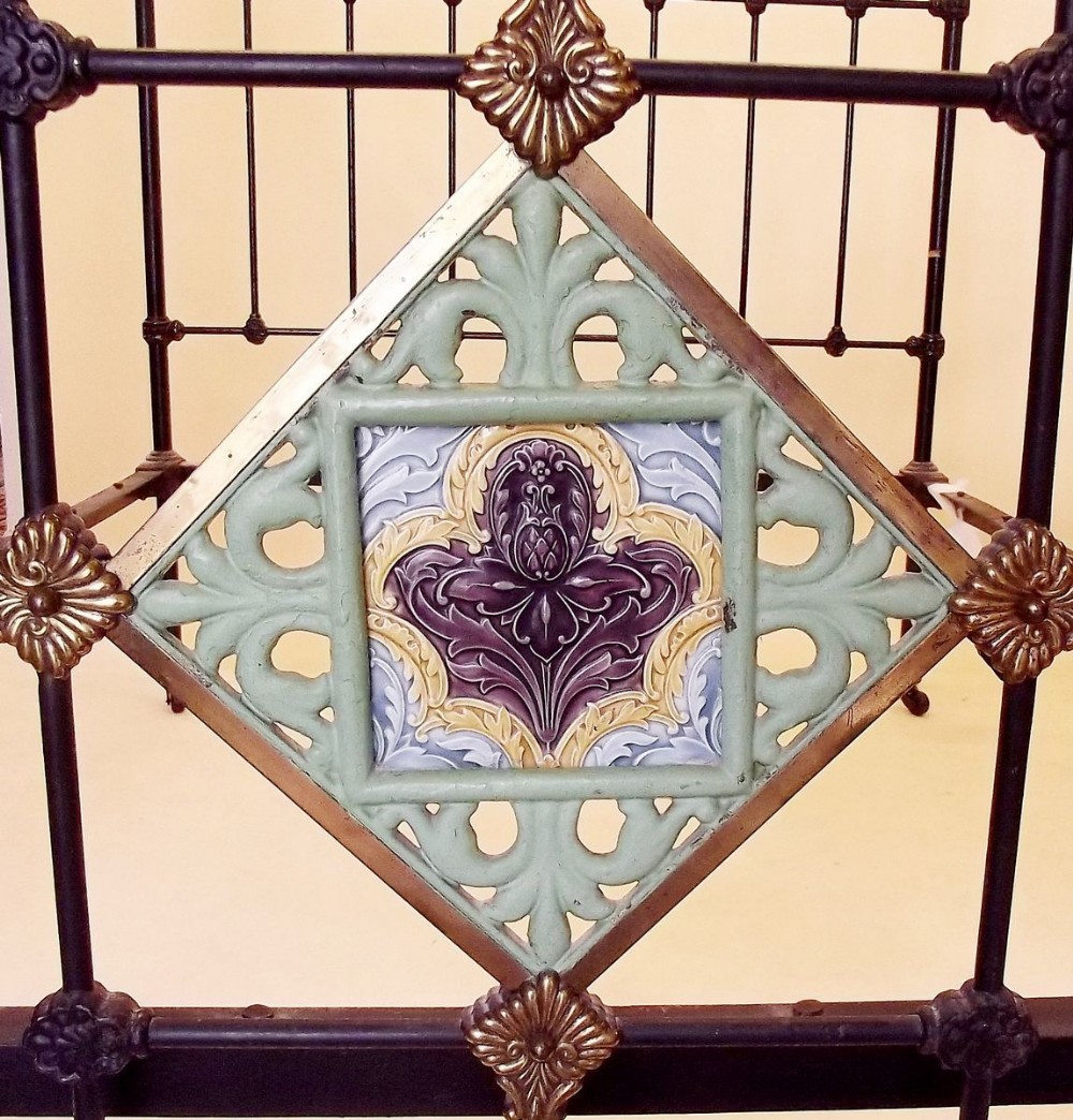 A Victorian brass and iron double bedhead and end inset Victorian Majolica tile, with pair or irons