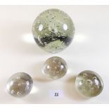 A Victorian large glass dump weight and three similar smaller paperweights