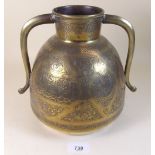 A Persian brass two handled pot with engraved decoration - 20cm tall