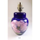 A Moorcroft table lamp painted magnolia on a blue ground - 22cm