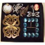 A box of assorted buckles and brooches