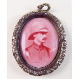 A Victorian painted enamel miniature of a soldier in oval locket with gold plated floral surround