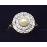 A platinum vintage cluster ring set pearl within double band of diamonds