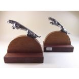 A pair of chrome Jaguar car mascots mounted as bookends