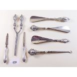 A pair of silver handled glove stretchers, three shoe horns, button hook and two manicure tools
