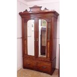 A Victorian walnut wardrobe with two glazed and mirrored doors over drawers