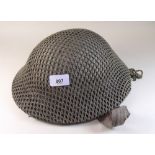 A WWII Brodie helmet with camouflage netting and liner