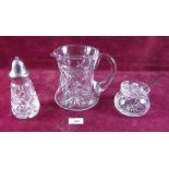 A cut glass jug, preserve pot and sugar castor