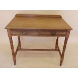 An Edwardian light oak side table with two frieze drawers on turned supports by Wilkinson and Son,
