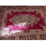 A large Persian style modern carpet with floral medallion decoration on a red ground 383 x 299cm