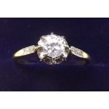 An 18 carat gold solitaire diamond ring on chip diamond set shoulders (unmarked) - size L