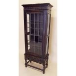 A Victorian dark oak Jacobean style lead glazed single door display cabinet, one glass a.f