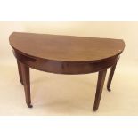 A 19th century mahogany D end console table on square supports and brass feet and castors