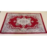 A Chinese red and cream rug 178 x 121cm