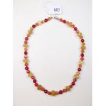 A necklace of semi-precious orange and red stones with 18 carat gold clasp