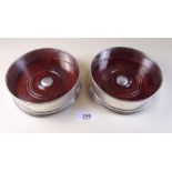 A pair of silver and mahogany bottle coasters