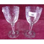 A pair of tall cut glass wine glasses with cut decoration