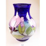 A large blue Moorcroft vase painted magnolia on a blue ground - 24cm