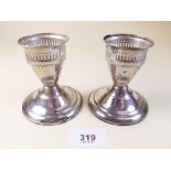 A pair of sterling silver dwarf candlesticks