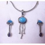 A silver and turquoise pendant and earrings